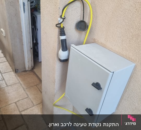 כבל חשמל צהוב מחובר לקופסת חשמל על קיר